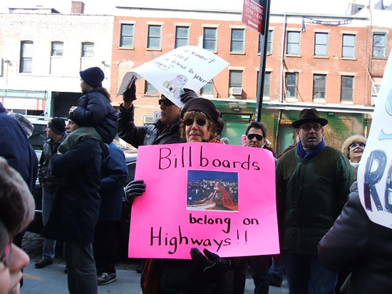 Village resident holds sign protesting the erection of billboards in front of the hotel Gansevoort