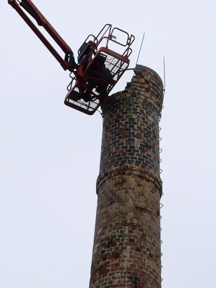 crane dismantling smokestack of Superior Ink building