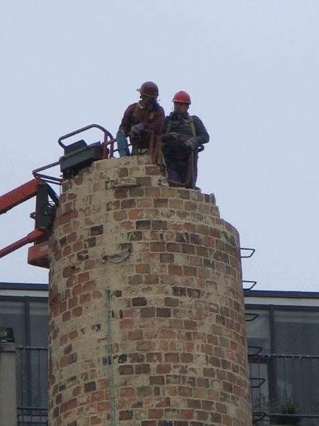 workers dimantle smokestack at Superior Inks building